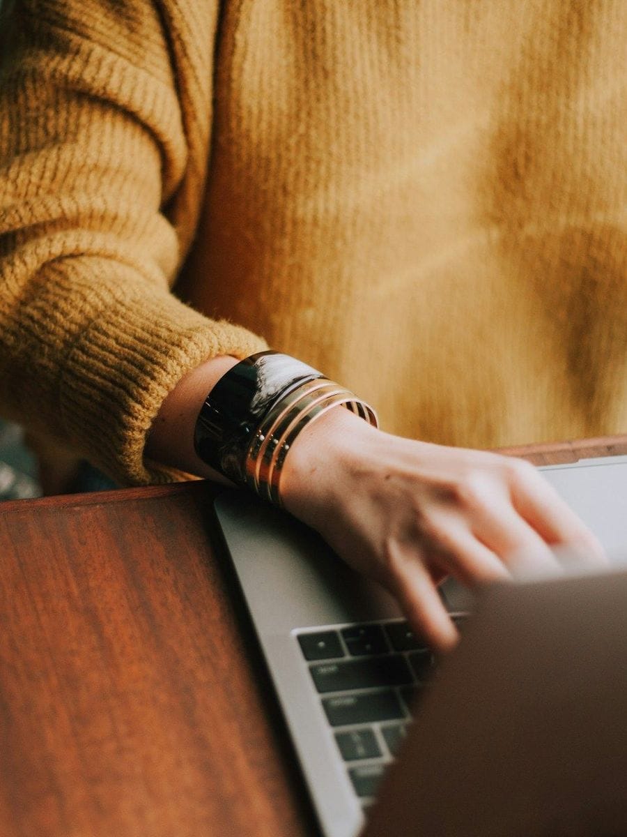 Manneskja að nota fartölvu við skrifborð. Mynd frá Christin Hume af Unsplash.com.