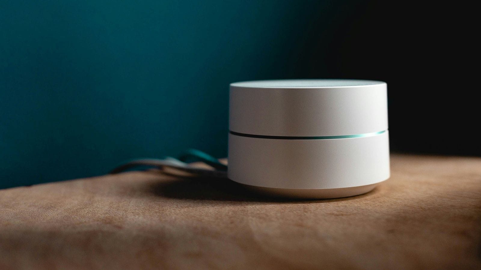 Google netbeinir tengdur við ljósleiðara með grænan málaðan vegg fyrir aftan ofan á viðarborði.