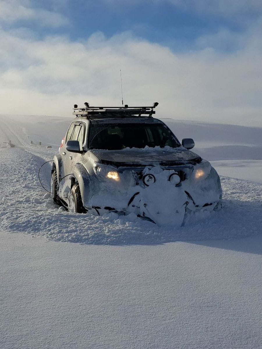 Jeppi í miklum snjó upp á fjalli
